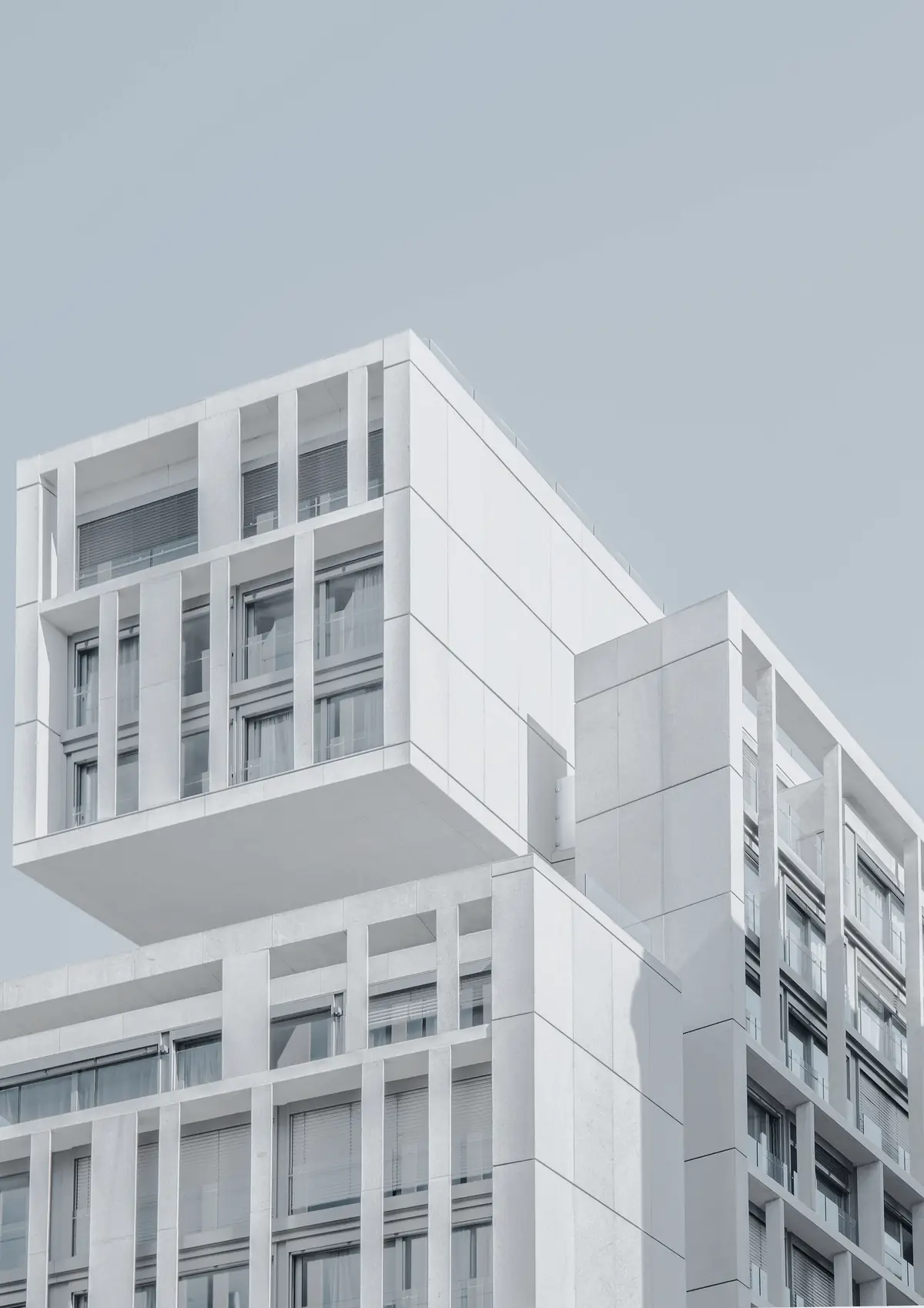 Fachada de edifício branco com linhas geométricas contra o céu